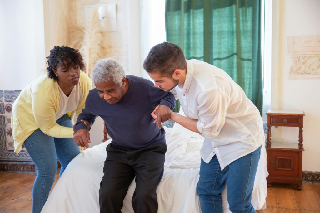 two young adult supporting an old man to walk